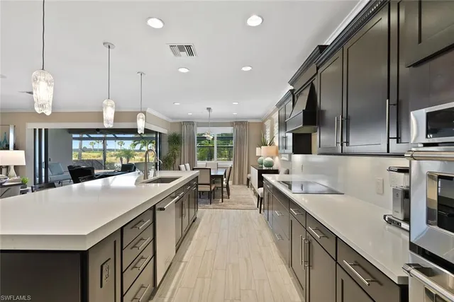 a large kitchen with kitchen island a sink a stove a dining table and chairs