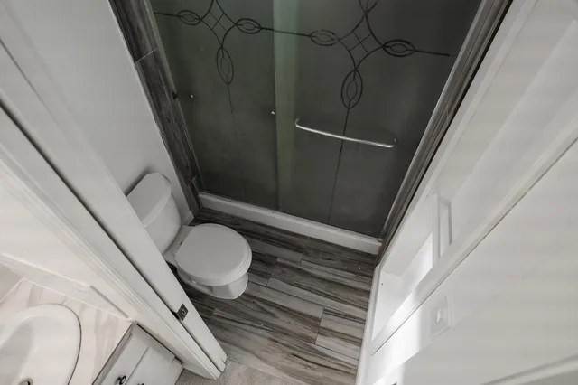 a bathroom with a granite countertop sink toilet and shower