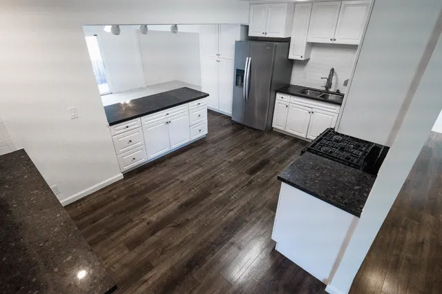 a kitchen with granite countertop a refrigerator and a stove