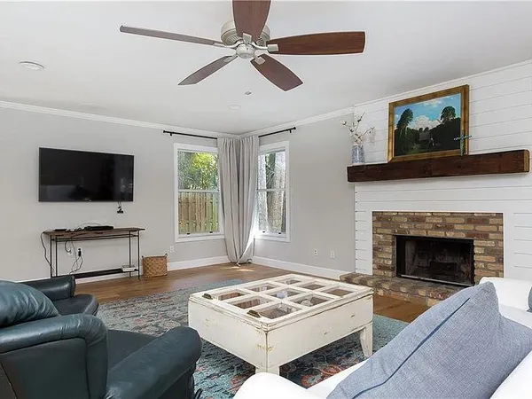 a living room with furniture a flat screen tv and a fireplace