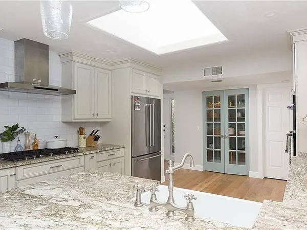 a kitchen with stainless steel appliances granite countertop a refrigerator and a sink