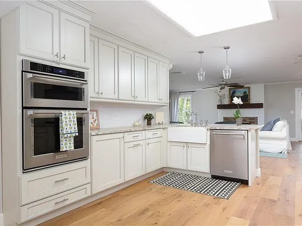 a kitchen with granite countertop a refrigerator stove and white cabinets