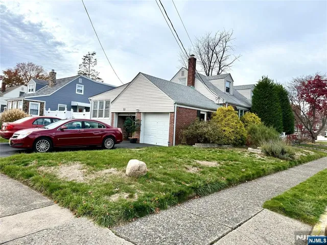 a front view of a house with a garden and trees