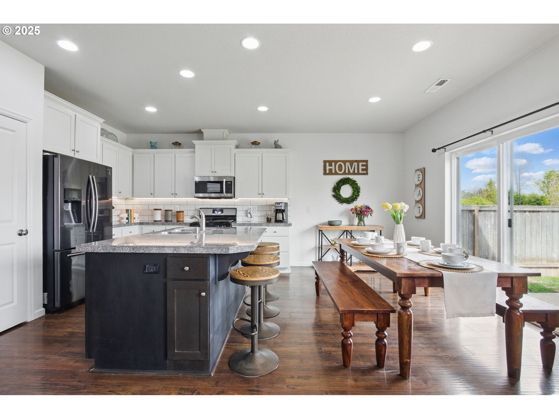 262 North 34th Court Ridgefield, WA 98642 - Photo 11 of 27 a kitchen with stainless steel appliances kitchen island granite countertop a refrigerator a sink a stove a dining table and chairs