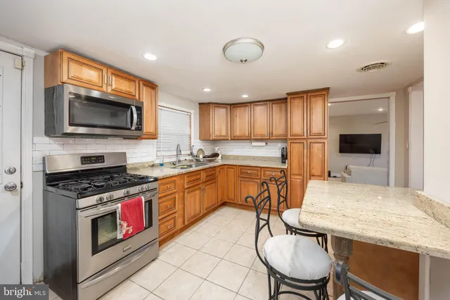 a kitchen with stainless steel appliances granite countertop a stove a sink dishwasher a microwave oven with granite countertops and cabinets