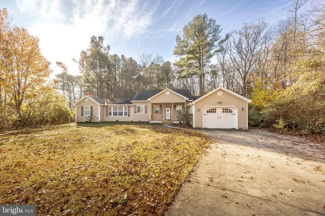 a view of a house with a yard covered in snow