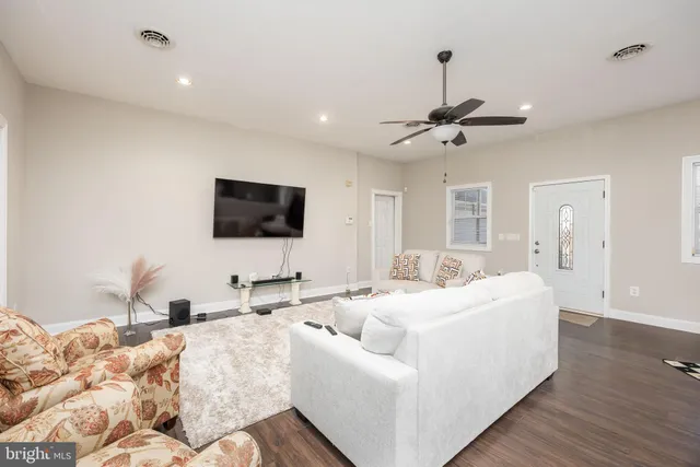 a living room with furniture ceiling fan and a rug