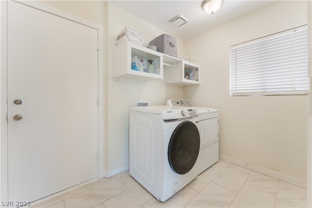 8872 Chapman Point Las Vegas, NV 89129 - Photo 25 of 29 Functional laundry space featuring modern appliances and clever storage solutions.