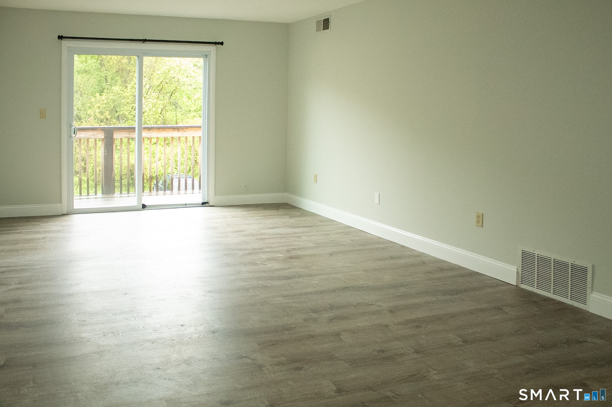 10 Georgetown Drive, Unit J Enfield, CT 06082 - Photo 5 of 15 a view of an empty room with wooden floor and a window