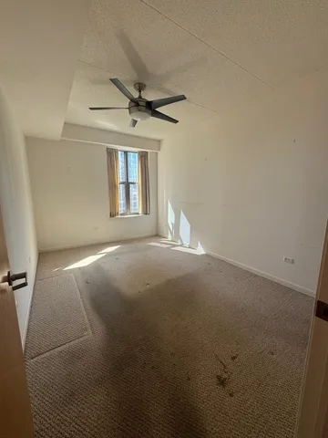 en empty room with windows and ceiling fan