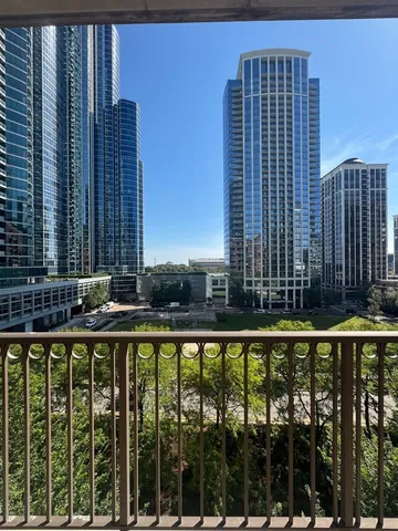 a view of balcony with a floor to ceiling window and tall tree