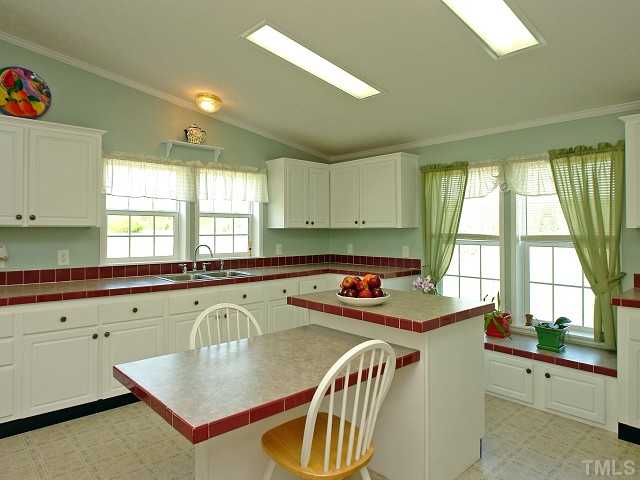 10829 Old Raleigh-Wilson Road Middlesex, NC 27557 - Photo 5 of 12 a kitchen with a table chairs sink and cabinets