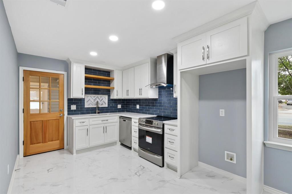 10879 Cassandra Way Dallas, TX 75228 - Photo 11 of 36 a kitchen with stainless steel appliances granite countertop a stove a sink and a refrigerator