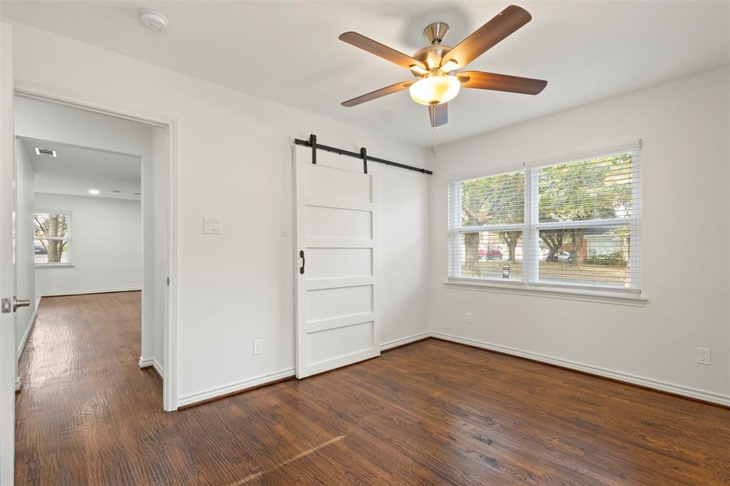10879 Cassandra Way Dallas, TX 75228 - Photo 20 of 36 an empty room with wooden floor chandelier fan and windows