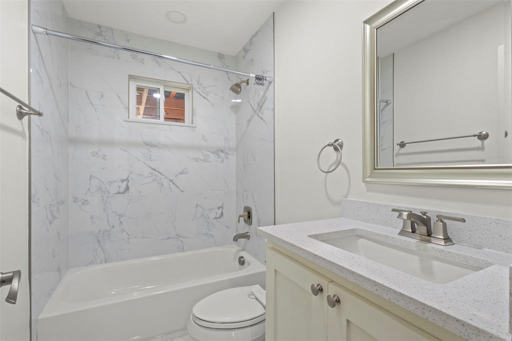 10879 Cassandra Way Dallas, TX 75228 - Photo 26 of 36 a bathroom with a granite countertop sink a toilet and a bathtub
