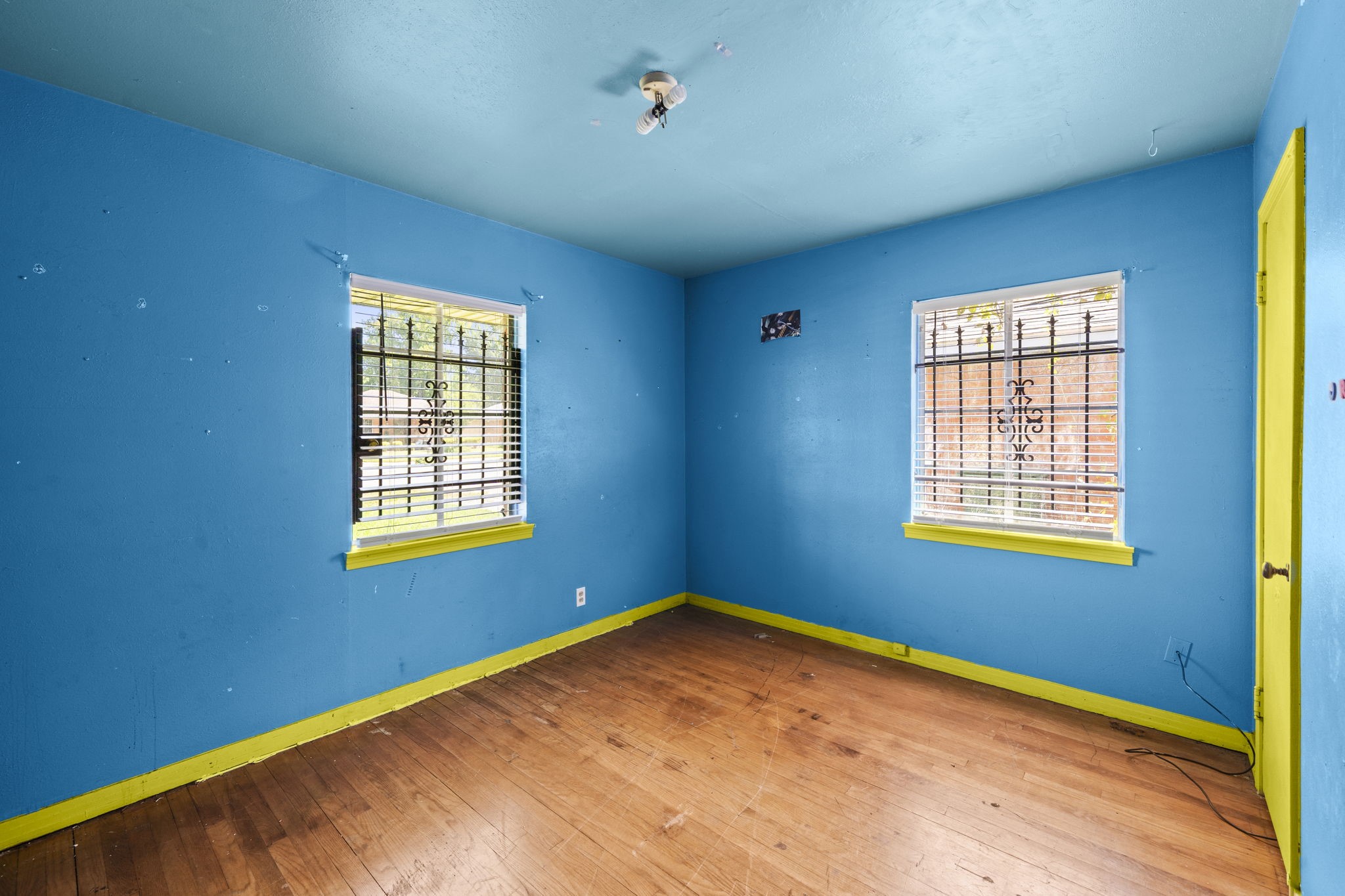 5810 Langley Road Houston, TX 77016 - Photo 15 of 20 The bright blue bedroom gives another honest look at the property’s current condition. The room is ready for a full cosmetic reset and a more neutral presentation.