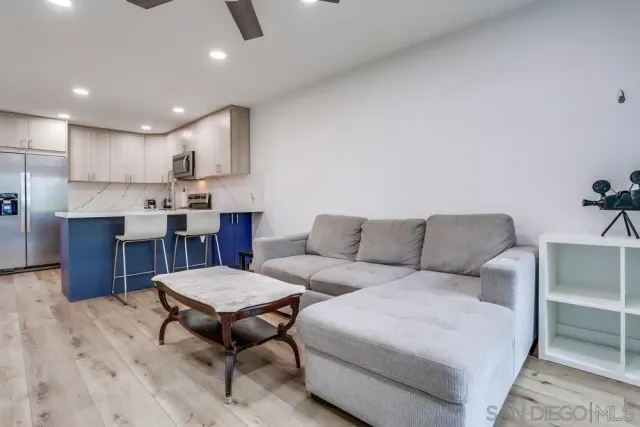 a living room with furniture a kitchen view and a dining table