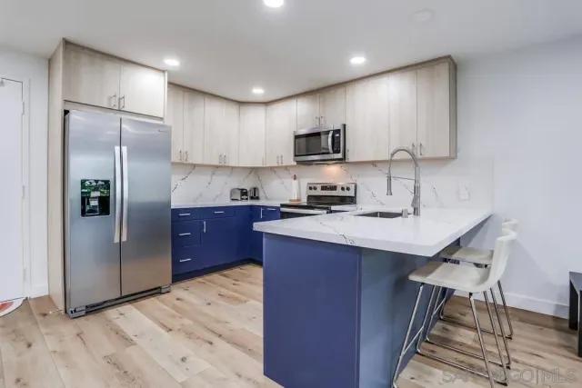 a kitchen with stainless steel appliances granite countertop a refrigerator a sink a stove a microwave a counter space and cabinets