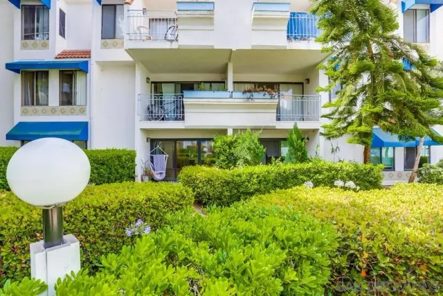 a view of a house with a fountain and potted plants