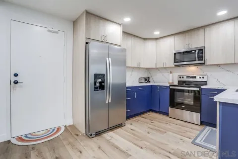 a kitchen with stainless steel appliances granite countertop a refrigerator and a stove top oven