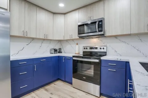 a kitchen with stainless steel appliances granite countertop wooden cabinets and a stove top oven