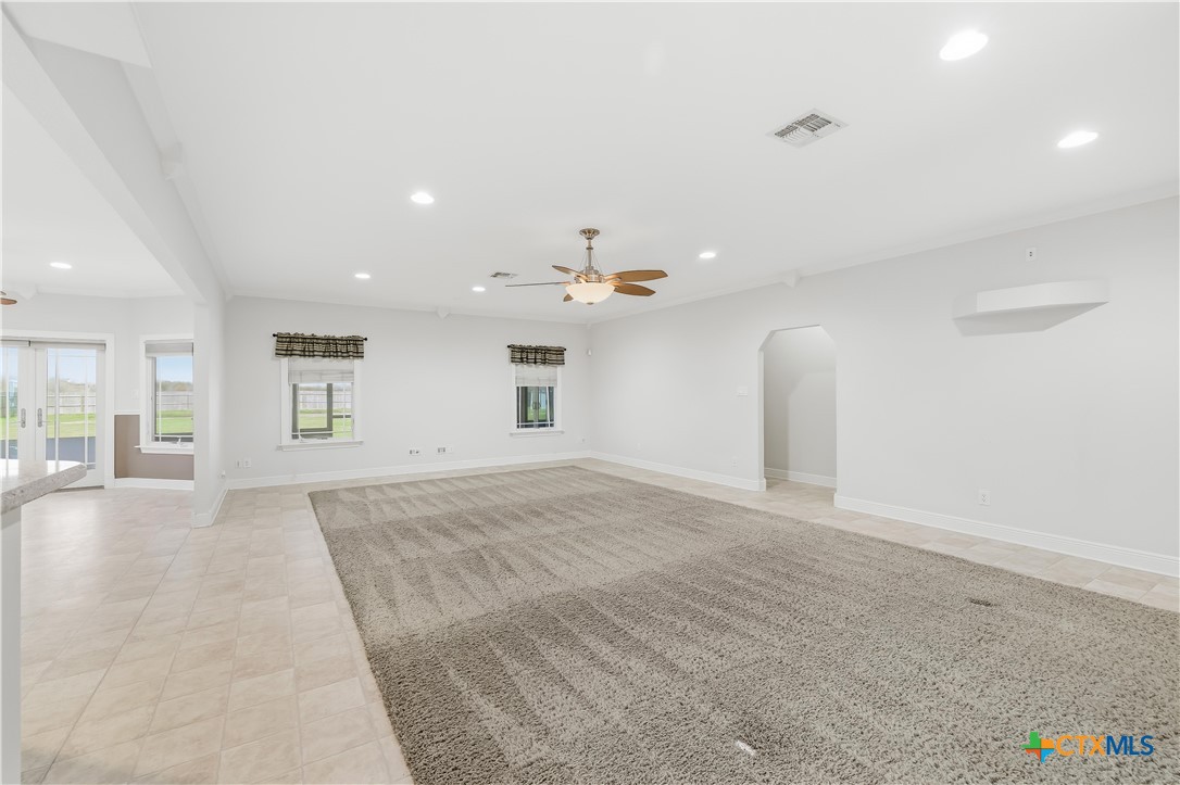 1118 East Maxwell Ditch Road Port Lavaca, TX 77979 - Photo 14 of 36 an empty room with a kitchen and chandelier fan