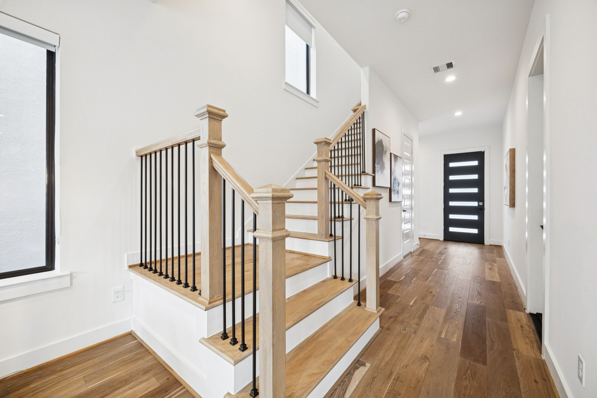 1739 Ojeman Point Lane Houston, TX 77055 - Photo 17 of 35 Toward the entry, the staircase leads to the second-floor landing with the primary suite and two secondary bedrooms.