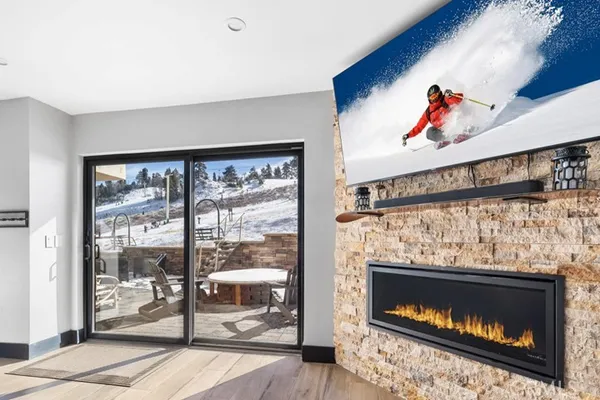 a living room with a fireplace and a floor to ceiling window
