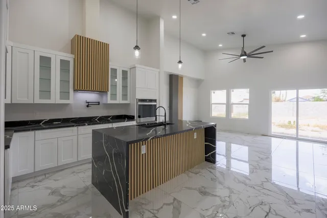 a kitchen with stainless steel appliances granite countertop a sink counter space cabinets and a large window
