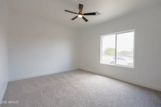 an empty room with a window and a fan