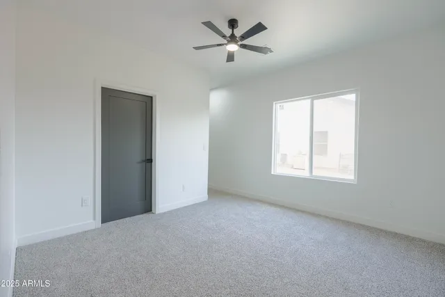 an empty room with a window and a fan