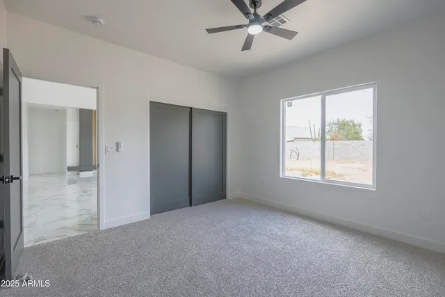 a view of a livingroom with a ceiling fan and window