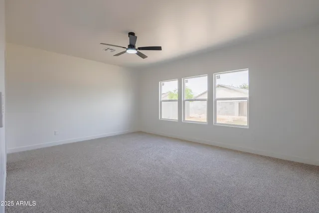 an empty room with a window and a fan