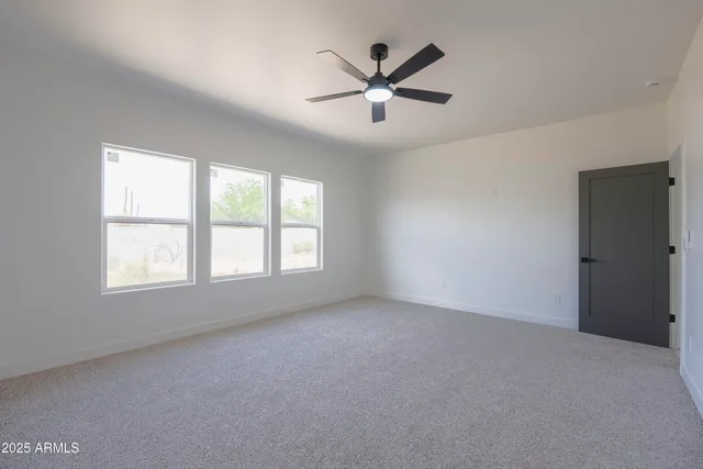 an empty room with a window and a fan