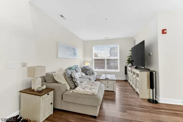 a living room with furniture a flat screen tv and a table