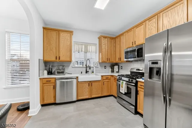 a kitchen with stainless steel appliances granite countertop a stove a sink dishwasher a refrigerator and a microwave oven