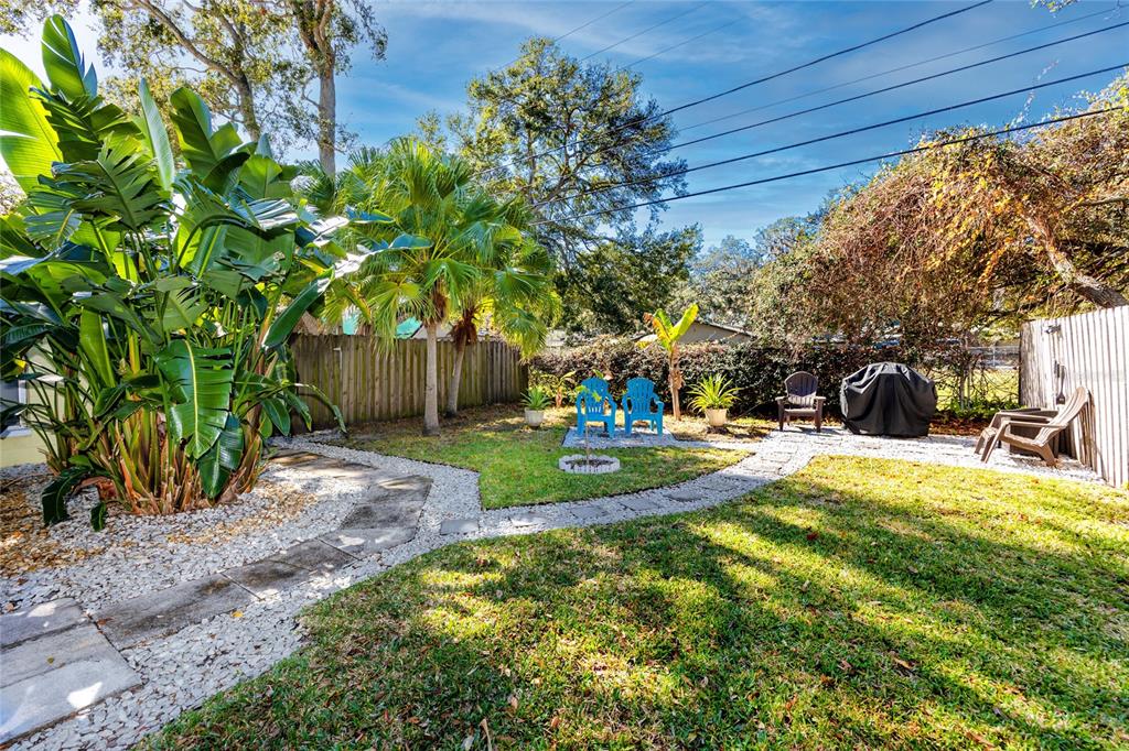 5596 100th Way North St. Petersburg, FL 33708 - Photo 57 of 67 a view of a backyard with table and chairs and a slide