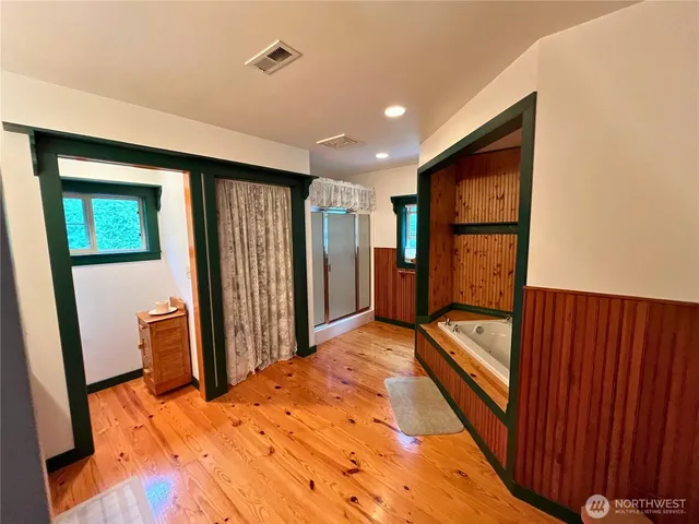 a bedroom with bed and wooden floor