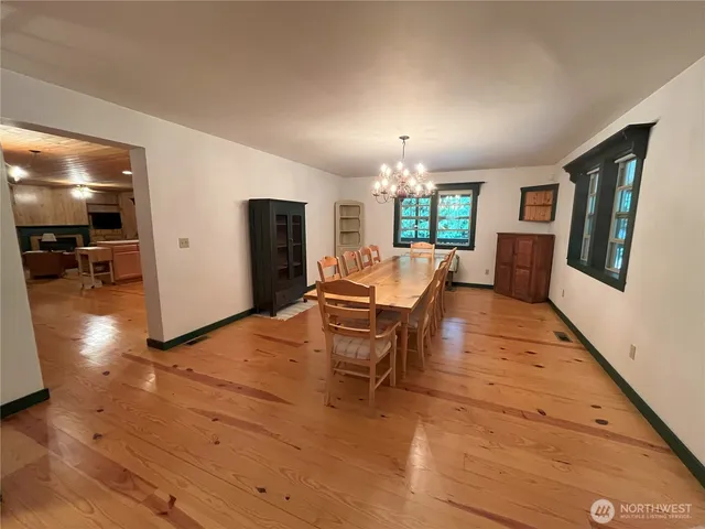 a living room with furniture a chandelier and a dining table