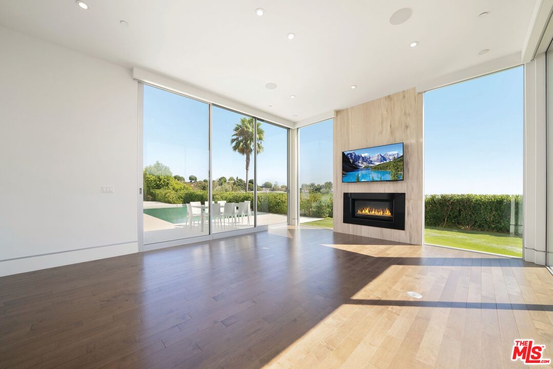 a view of an empty room with a fireplace and a window