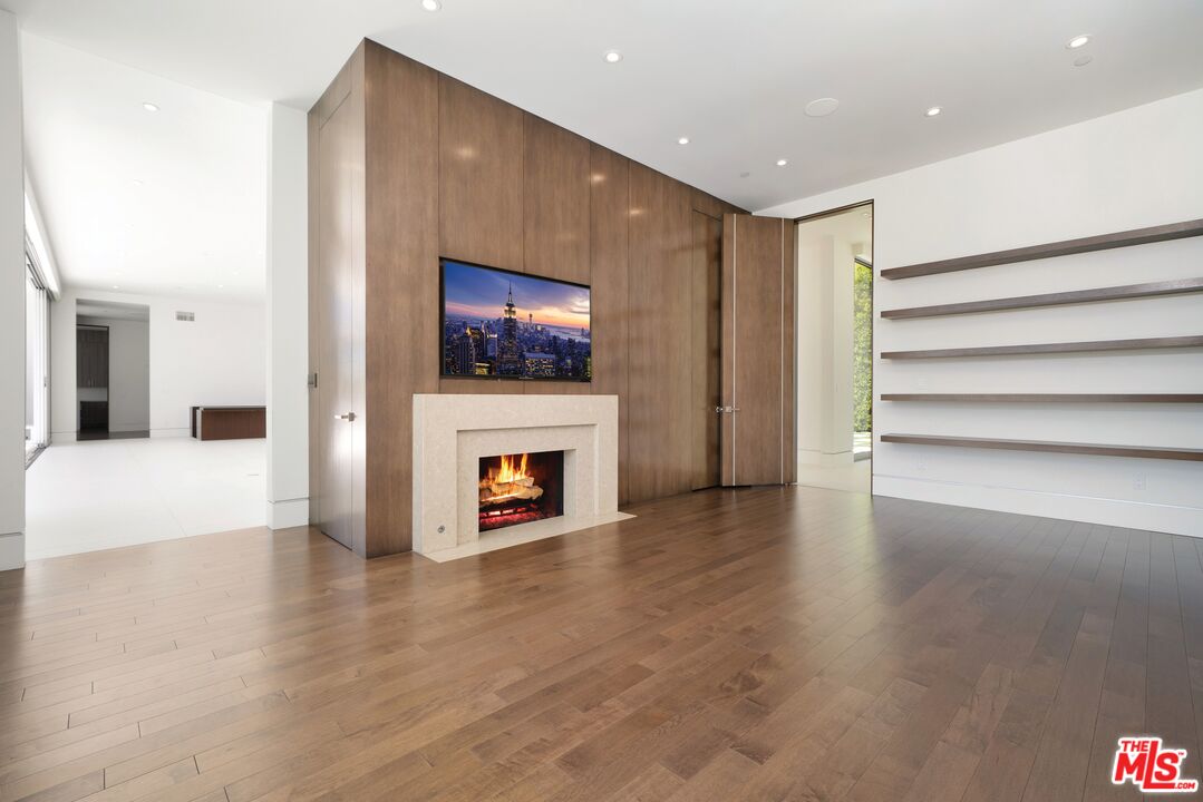 1115 Wallace Ridge Beverly Hills, CA 90210 - Photo 4 of 8 a view of an empty room with wooden floor and a fireplace