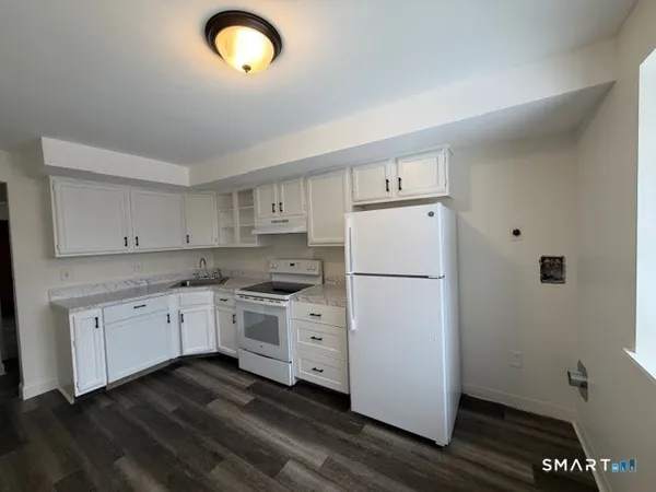a kitchen with cabinets appliances and wooden floor