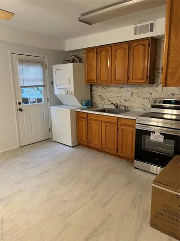 a kitchen with granite countertop a stove top oven sink and cabinets