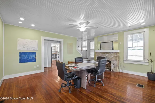 a view of a dining room with furniture a chandelier and wooden floor
