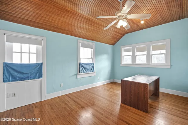 a room with wooden floors and a ceiling fan