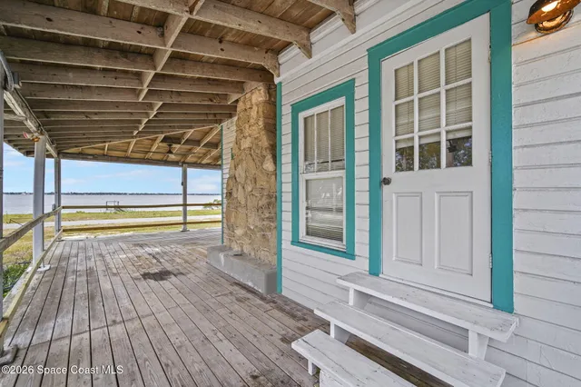 a view of a porch with wooden floor and fence