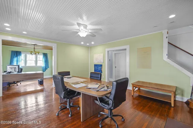 a workspace with furniture wooden floor and a chandelier
