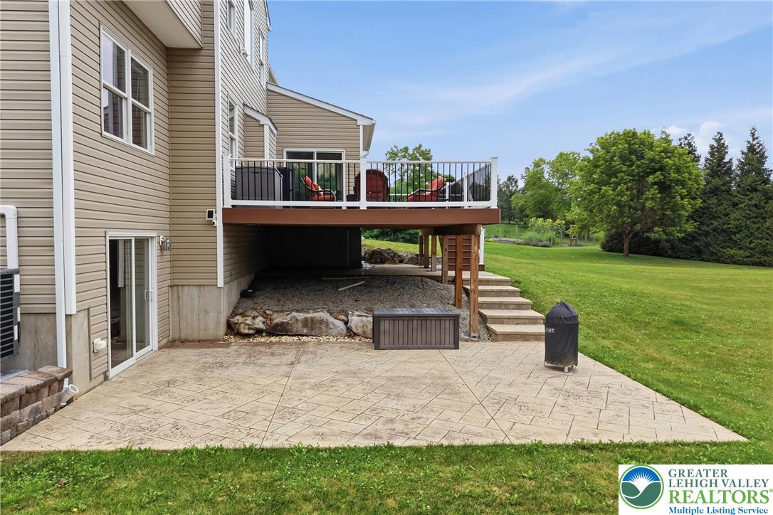 1212 Miller Road Wind Gap, PA 18091 - Photo 61 of 72 A ground-level patio and elevated deck extend from the home's rear, offering diverse outdoor enjoyment.