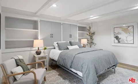 a bedroom with a bed and a view of living room
