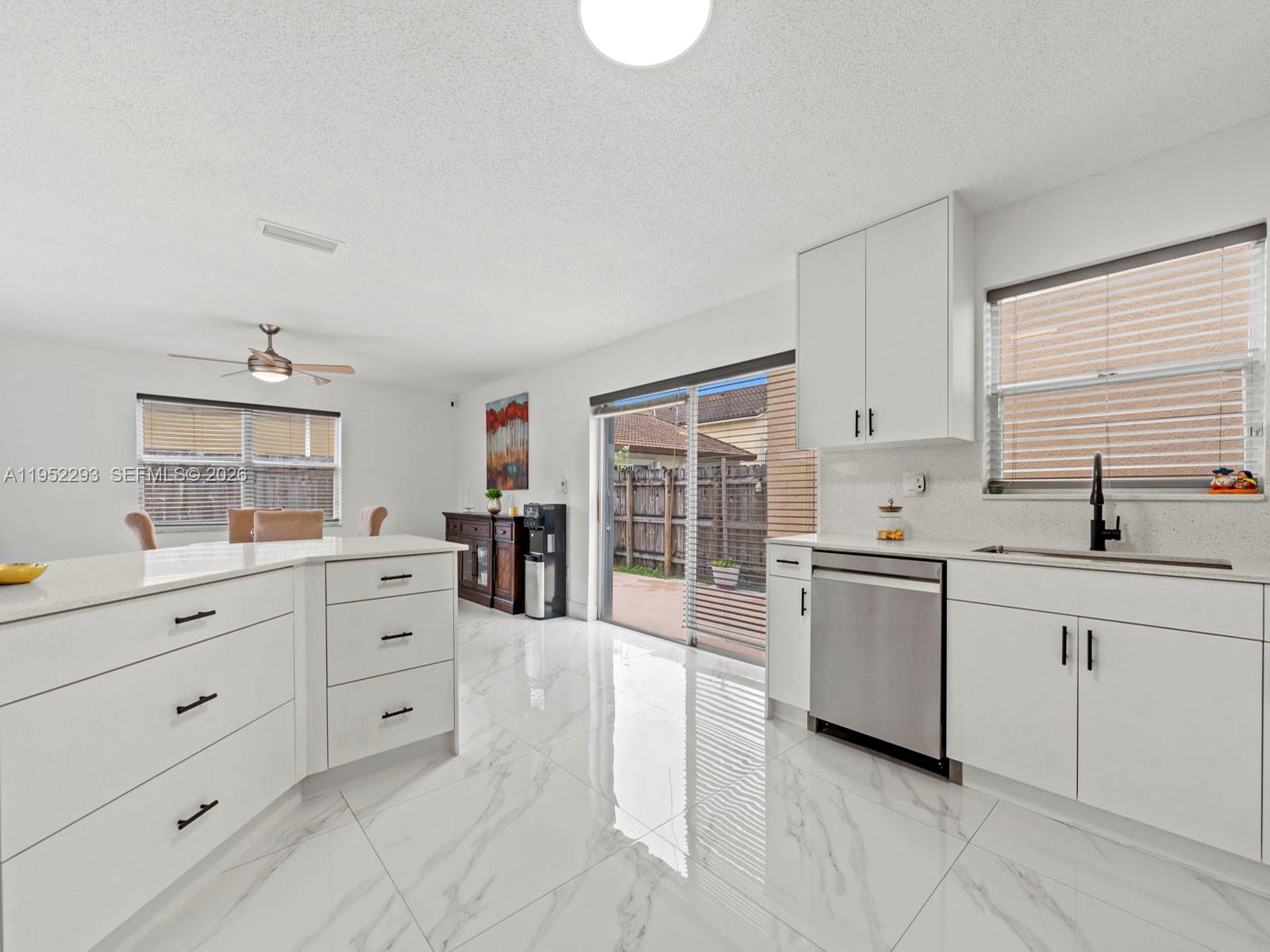 15626 Southwest 100th Terrace Miami, FL 33196 - Photo 11 of 30 a kitchen with granite countertop white cabinets and white appliances